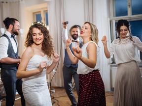 A young bride with other guests dancing on a wedding reception.