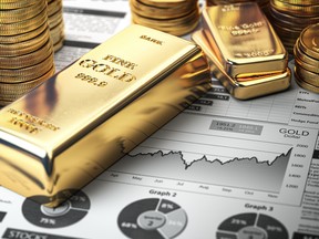 Gold bar, ingots and coins on a financial  report.