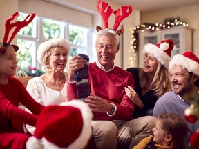 Multi-Generation Family Exchanging And Opening Gifts Around Christmas Tree At Home