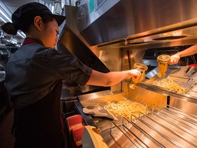 McDonald's Japan Swing Manager Miwa Suzuki sprinkles salt on french fries on January 25, 2016 in Tokyo, Japan. (Photo by Christopher Jue/Getty Images)