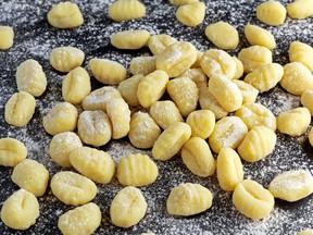 Uncooked homemade gnocchi on stone cutting floured board