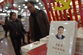 Customers walk past a book about Chinese President Xi Jinping entitled "The Governance of China" at a bookstore in Beijing on February 28, 2018. 
GREG BAKER/AFP via Getty Images