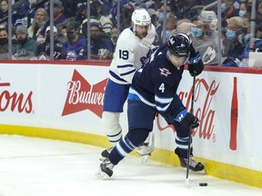Winnipeg Jets defenceman Neal Pionk (4) skates away from Toronto Maple Leafs forward Jason Spezza (19) during the first period at Canada Life Centre in Winnipeg Dec. 5, 2021.