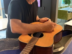 Alex Lifeson of Rush signs Greg Godovitz's guitar to raise money for B.C. flood victims.