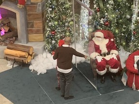Plexiglass separates Santa from his visitors at Santa’s Christmas Village in Mississauga’s Erin Mills Town Centre.