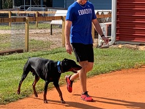 Romano and his Doberman, Otto, who is also enjoying his stay at the academy, cavorting with the barnyard animals housed there. Rob Longley, Toronto Sun)