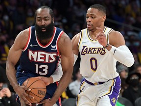 Russell Westbrook of the Los Angeles Lakers defends James Harden of the Brooklyn Nets as he drives to the basket in the first half of the game at Crypto.com Arena on Dec. 25, 2021 in Los Angeles, Calif.