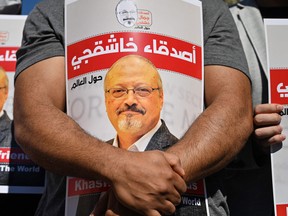 In this file photo taken on October 2, 2020, friends of murdered Saudi journalist Jamal Khashoggi hold posters bearing his picture as they attend an event marking the second-year anniversary of his assassination in front of Saudi Arabia Istanbul Consulate.