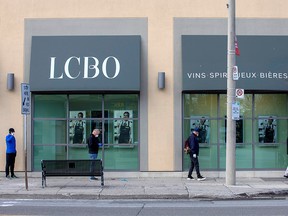 People wait outside of the LCBO to purchase alcohol in Toronto April 9, 2020.