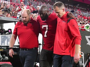 Leonard Fournette of the Tampa Bay Buccaneers is helped off the field after an injury during the  quarter of the game against the New Orleans Saints at Raymond James Stadium on December 19, 2021 in Tampa, Florida.