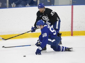 Maple Leafs’ Timothy Liljegren (above) tries to get around Michael Bunting during practice earlier this week. Liljegren was placed on the COVID protocol list yesterday.
