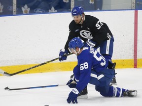 Toronto Maple Leafs Michael Bunting (58) tries to block a pass by teammate Timothy Liljegren (37) during practice in Toronto on December 26, 2021.
