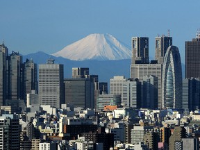 Japan's Mt. Fuji is seen in the background between skyscrapers in Tokyo's Shinjuku area January 4, 2011.