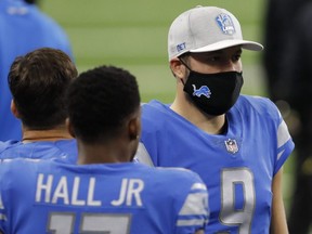 Lions quarterback Matthew Stafford (right) wears a mask on the sidelines before a game against the Washington Football Team at Ford Field in Detroit, Nov. 15, 2020.