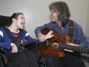 Chris McHardy plays his guitar for his daughter Kathleen at Variety Village on Friday December 17, 2021.