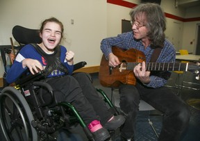 Chris McHardy plays his guitar for his daughter Kathleen at Variety Village on Friday, Dec. 17, 2021.