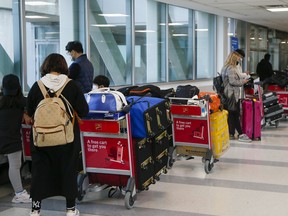 Long lines of passengers heading to hotels to quarantine are seen on March 1, 2021 in Toronto.