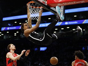 Nic Claxton of the Brooklyn Nets dunks the ball as Malachi Flynn of the Raptors looks on during the first half at Barclays Center on Tuesday, Dec. 14, 2021 in Brooklyn.