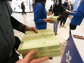 At the Scarborough Town Centre 1,000 rapid test Antigen COVID-19 packs were handed out for free. There are five test kits inside each package. The packs were doled out in just an hour with more coming on Friday at STC and various other locations around the GTA (Pictured)  Security officers hand over the packages to health officials to hand out to customers onThursday December 16, 2021. Jack Boland/Toronto Sun/Postmedia Network