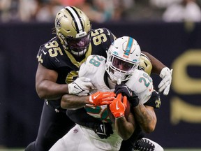 Saints defensive tackle Benito Jones (95) tackles Dolphins running back Duke Johnson (28) during second half NFL action at Caesars Superdome in New Orleans, Monday, Dec. 27, 2021.