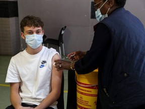 A health-care worker administers a dose of the Pfizer COVID-19 vaccine to a teenager, amidst the spread of the SARS-CoV-2 variant Omicron, in Johannesburg, South Africa, Thursday, Dec. 9, 2021.