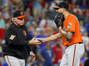 Baltimore Orioles manager Buck Showalter (left) takes the ball from starting pitcher Kevin Gausman, in the ninth inning of a baseball game against the Texas Rangers on July 29, 2017, in Arlington, Texas.