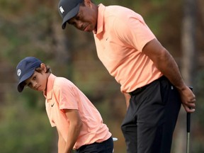Tiger Woods and son Charlie Woods look over a birdie attempt on the 15th hole during the first round of the PNC Championship at the Ritz Carlton Golf Club Grande Lakes in Orlando, yesterday.  Getty Images