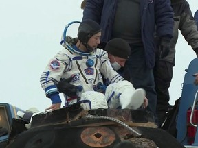 Ground personnel assist Japanese entrepreneur Yusaku Maezawa shortly after landing of the Soyuz MS-20 space capsule in a remote area outside Zhezkazgan, Kazakhstan, Dec. 20, 2021, in this still image taken from video.