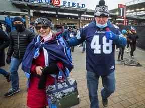 Toronto fans Joanne Weston and Dave Mahar leave BMO Field after the  Hamilton Tiger-Cats defeated the Toronto Argonauts in the CFL Eastern final on Dec. 5, 2021.