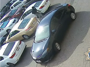 An image from surveillance video shows a suspect fleeing to a getaway vehicle after allegedly stealing something from the gold-colored car on April 12. Police said this was one of a robbery crew's more than 170 attacks in the San Francisco Bay area over a period of one year.