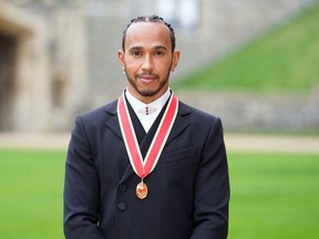 Lewis Hamilton poses for a photo after he was made a Knight Bachelor by Britain's Charles, Prince of Wales, during an investiture ceremony at Windsor Castle in Windsor, Britain, December 15, 2021.