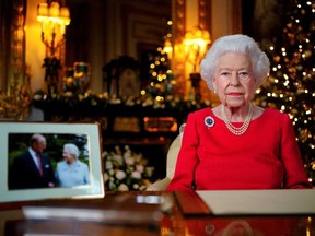 Queen Elizabeth records her annual Christmas broadcast in the White Drawing Room in Windsor Castle, next to a photograph of the Queen and the Duke of Edinburgh, in Windsor on December 23, 2021.