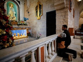 Worshipers pray ahead of Christmas morning mass at Saint Catherine's Church, in the Church of the Nativity, in Bethlehem in the Israeli-occupied West Bank, December 25, 2021.