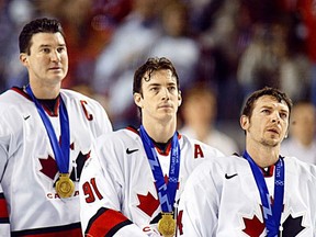 Canada's Mario Lemieux (L), Joe Sakic (C) and Theo Fleury (R) stand during the playing of the Canadian national anthem following Team Canada's gold medal victory at the 2002 Winter Games held in Salt Lake City, Utah.