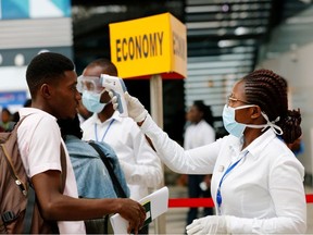 A health worker checks the temperature of a traveller as part of the coronavirus screening procedure at the Kotoka International Airport in Accra, Ghana January 30, 2020.