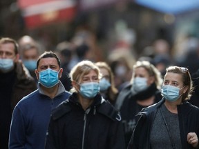 People, wearing protective face masks, walk on the Mouffetard street, amid the spread of the coronavirus disease (COVID-19) pandemic, in Paris, France, December 30, 2021.