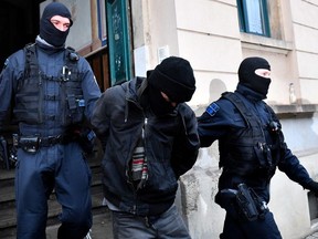 Police detain a suspect during raids in several locations in Dresden, Germany, December 15, 2021, as part of an investigation into what police said was a plot to murder the state's prime minister, Michael Kretschmer, by anti-vaccination activists. The searches in the city of Dresden targeted individual members of a group on the messaging program Telegram, where plans for the killing were discussed in connection with the state government's coronavirus curbs, police said.