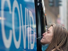 A woman takes a coronavirus disease (COVID-19) test at a pop-up testing site as the Omicron coronavirus variant continues to spread in Manhattan, New York City, U.S., December 27, 2021.