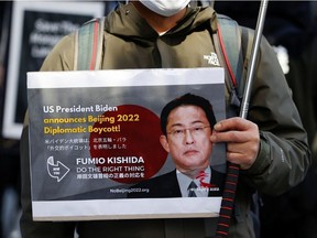A protester displays a sign against the Beijing 2022 Winter Olympic Games during the Asia Peace March in observance of Human Rights Day, in Tokyo, Japan December 11, 2021.