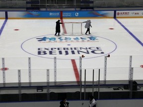 Staff members move a net as they maintain the rink, at an ice hockey competition venue for the 2022 Olympic Winter Games, inside the National Indoor Stadium,  in Beijing, China April 1, 2021.