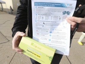 One thousand rapid test antigen COVID-19 packs, each containing five test kits, were handed out for free at the Scarborough Town Centre on Thursday, Dec. 16, 2021. Graeme Sweeney, seen here holding up his package of test kits, was near the front of the line and picked up his pack early to be safe for Christmas.