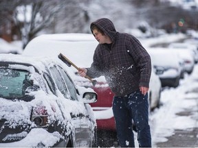 Remember this? Etobicoke resident Paul Mailhot is pictured last Christmas Day clearing snow off his car. While we may get more white stuff this Christmas, temperatures will be unseasonably mild this week.