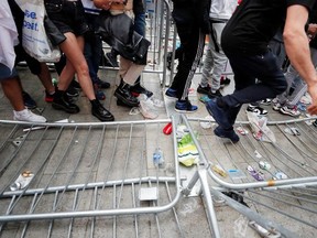 Fans gather for Italy v England - Wembley Stadium, London, Britain - July 11, 2021 Picture taken July 11, 2021 England fans walk by fallen barriers outside Wembley Stadium before the match.