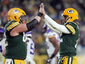 Quarterback Aaron Rodgers of the Green Bay Packers (right) is congratulated by centre Lucas Patrick after a touchdown during the fourth quarter of their team's game against the Minnesota Vikings at Lambeau Field on Jan. 2, 2022 in Green Bay, Wisconsin.