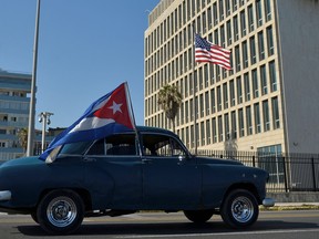 Cubans drive past the U.S. embassy during a rally calling for the end of the U.S. blockade against Cuba, in Havana, March 28, 2021.