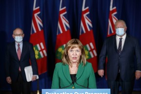 Ontario Premier Doug Ford, right, and Chief Medical Officer of Health Dr. Kieran Moore flank the Minister of Health Christine Elliott during a press conference at Queen's Park in Toronto, Dec. 15, 2021.