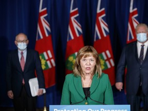 Ontario Premier Doug Ford, right, and Chief Medical Officer of Health Dr. Kieran Moore flank the Minister of Health Christine Elliott during a press conference at Queen's Park in Toronto, Dec. 15, 2021.