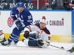 Connor McDavid #97 of the Edmonton Oilers battles for the puck against Auston Matthews #34 of the Toronto Maple Leafs during the first period an NHL game at Scotiabank Arena on March 29, 2021 in Toronto.