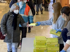 Menschen holen am Montag, 3. Januar 2022, im Einkaufszentrum Place d'Orléans Antigen-Schnelltestkits ab.