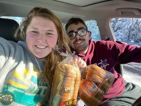 Casey Holihan Noe, 23 and husband John Noe holding loaves of bread.